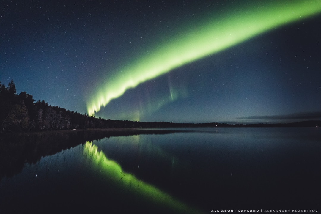 Amazing aurora borealis reflecting in the autumn lake. September in Rovaniemi Lapland Finland.